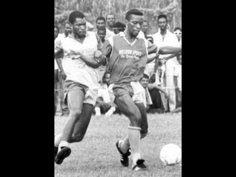 RENO’S Cecil Pringle (right), holds off the challenge of Wadadah’s Paul Burkett during the Western Sports Super Cup final at Frome in Westmoreland in 1989.