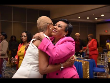 Rebecca Pringle (right), president of the National Education Association in the United States, embraces Fayval Williams, minister of education and youth, during the Jamaica Teachers’ Association Status of Women Conference, held at The Jamaica Pegasus hot