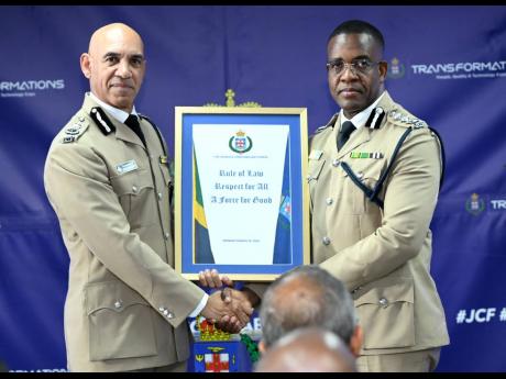 Outgoing Commissioner of Police Major General Antony Anderson (left) hands over command of the Jamaica Constabulary Force (JCF) to Commissioner of Police Dr Kevin Blake at the JCF Change of Command ceremony at the Office of the Commissioner of Police on Ol