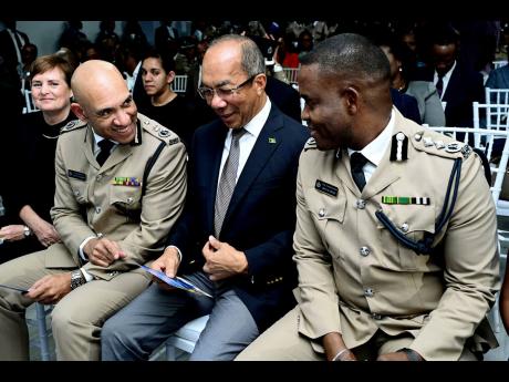 Rudolph Brown/Photographer
Dr. Horace Chang (second right), Deputy Prime Minister and Minister of National Security chats outgoing Commissioner of Police Major General Antony Anderson (second left) and new Commissioner of Police Dr. Kevin Blake at the Jama