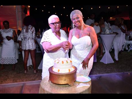 Dollis Campbell (right) cuts a cake on Night Two of her 60th birthday celebration with her mother, Ivy Williams.