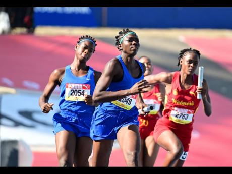 Wolmer's Girls School (right) goes in chase of Hydel High School during their Class 1 4x100-metre heat at the ISSA/GraceKennedy Boys and Girls' Athletics Championships inside the National Stadium today. 