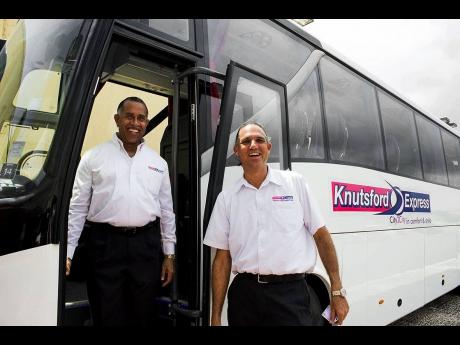 File photo shows Knutsford Express’ director Anthony Copeland (left) and CEO Oliver Townsend standing aside one of the luxury coaches operated by the company. Townsend announced that Knutsford Express will be expanding its luxury transportation service t