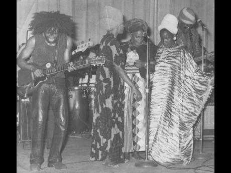 Bob Marley and The I-Three performing on stage.
