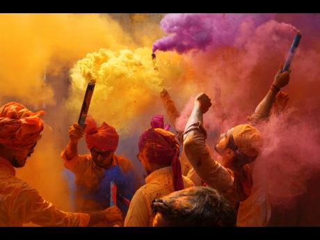 People sing, dance and throw colours at each other to celebrate Holi festival in Hyderabad, India in March 2023.
