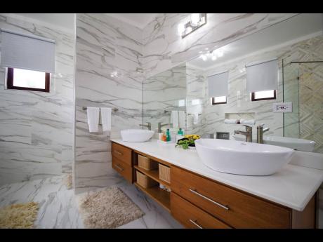 The show-stopping main bathroom, with floor-to-ceiling height porcelain tiles and mirrored walls.