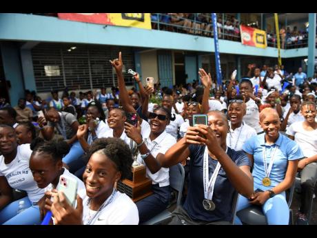 Members of the track and field team celebrating at Edwin High School during yesterday’s campus celebration of the Frankfield, Clarendon-located institution’s 10th hold on the Girls’ Champs trophy at the ISSA Boys and Girls’ Championships.