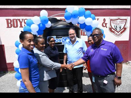 Mark Golding (fourth left), leader of the Opposition and member of parliament for St Andrew Southern, shares in the handover of a 1,000-gallon water tank at the Boys’ Town Primary School on Monday, March 25, with (from left): Shantelle Stewart of Unicome