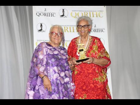 Past QORIHC queen and founder of L’Acadco, L’Antoinette Stines (left) presents the Tribute Queen Award to her mentor and former dance teacher, Alma Mock Yen.