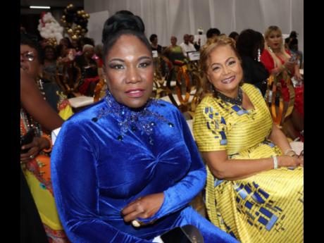 Audrey Reid (left), stage and screen actress, and Mary Isaacs, recording artiste, await their turn to receive their acknowledgements as QORIHC Queens at the seventh staging of the event held at the Karl Hendrickson Auditorium, Jamaica College on Sunday.