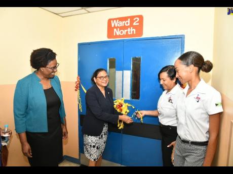 Chief Medical Officer, Dr Jacquiline Bisasor-McKenzie (second left) cuts the ribbon to officially open the newly renovated Ward 2 North at the Kingston Public Hospital (KPH) on Tuesday. Looking on (from left) are Acting Chief Executive Officer at KPH, Dr N