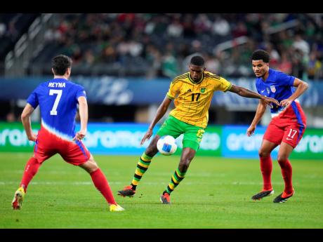 Jamaica’s Damion Lowe (centre) controls the ball against United States’ Malik Tillman (right) and Gio Reyna (left) during the second half of a Concacaf Nations League semifinal match on Thursday, March 21, 2024, in Arlington, Texas. 
