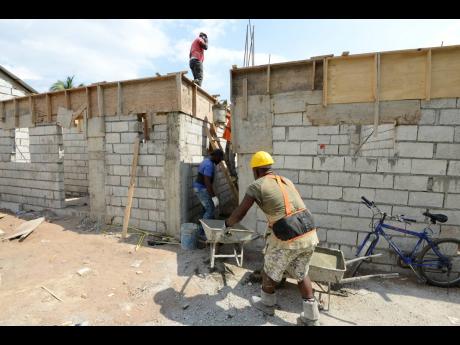In this 2019 photo workers are seen constructing houses in Denham Town under the zones of special operations social intervention programme. 