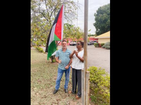 Jalil Dabdoub and Angela Brown Burke raising the Palestinian flag at the People’s National Party’s Old Hope Road, St Andrew, headquarters. 