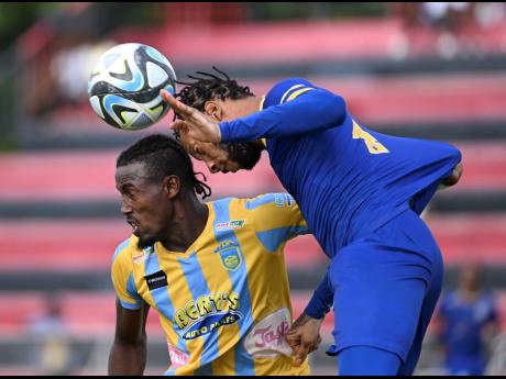 Javane Bryan (left) of Waterhouse battles for the ball with Molynes United defender Odane Samuels during their  Jamaica Premier League encounter at the Anthony Spaulding Sports Complex yesterday.