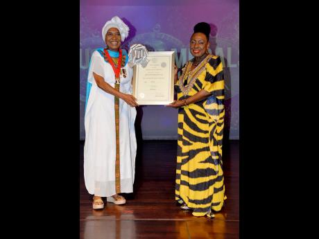 Barbara Blake-Hannah (left), receives her Silver Musgrave Medal and certificate from Minister of Culture, Gender, Entertainment, and Sport, Olivia Grange.