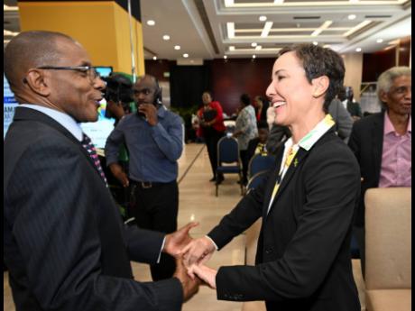 Courtney Campbell, chair of the 10th Biennial Diaspora Conference and president and CEO of the VM Group, speaks with Senator Kamina Johnson Smith, minister of foreign affairs and foreign trade, during yesterday’s launch of the conference at the Ministry 