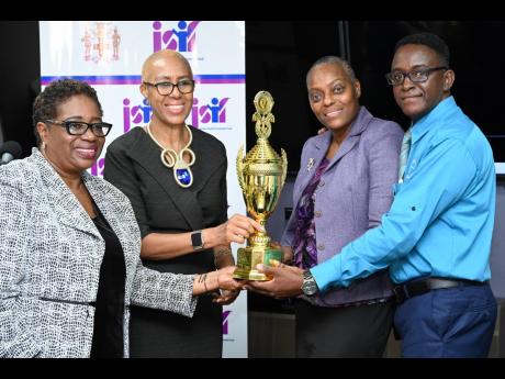 Education Minister Fayval Williams (second left) and Mona Sue-Ho, senior manager of social development at the Jamaica Social Investment Fund, present the Best Kept Grounds trophy to Cheryl Grant-Mitchell (second right) and Michael Thompson, principal and v