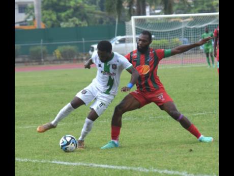 Anthony Nelson (left)  of Tivoli Gardens FC and Montego Bay United’s Owayne Gordon battle for the ball during their Wray and Nephew-sponsored Jamaica Premier League match at the Montego Bay Sports Complex yesterday. Montego Bay United won 2-1.
