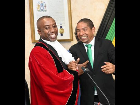 Former Kingston Mayor Delroy Williams (right) greeting his successor, Andrew Swaby.