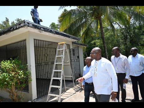 Professor Densil Williams (forefront), pro vice-chancellor and campus principal of The UWI, Mona, looking at a house  with (from left) Milton McIntyre, of Kayani Construction Ltd; Milton Dennis, acting estate manager of The UWI Mona Campus, and Christopher