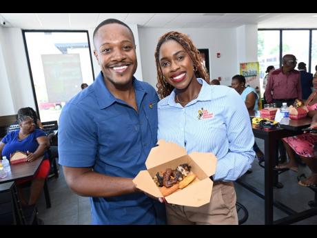 Brand manager of Best Dressed Chicken Arielle Oliver (right) mingles with digital content creator Akeem Boothe over Island Grill’s savoury offerings.