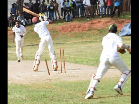 May Day High's Javed Williams (centre) had his stumps flying from a delivery from Manchester High's Rhevon Morgan (left) on the first day of the ISSA/GK Insurance Headley Cup final at Manchester on Wednesday. Wicketkeeper Pajay Nelson helps Morgan celebrat