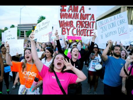 FILE – Protesters in Phoenix shout as they join thousands marching around the Arizona state Capitol after the U.S. Supreme Court decision to overturn the landmark Roe v. Wade abortion decision on June 24, 2022. A stunning abortion ruling this week in Apr