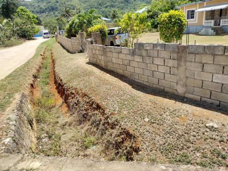 The trench cutting off direct access to the roadway that was dug in front of Coral Brissett’s house in Jackson Town, Trelawny.