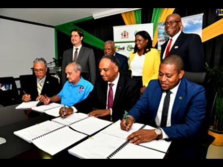 Minister of Agriculture, Fisheries and Mining, Floyd Green (seated right); Managing Director, Jamaica Social Investment Fund (JSIF), Omar Sweeney (seated second right); Director of Projects, Champion Industrial Equipment and Supplies Limited, Courtney Harf