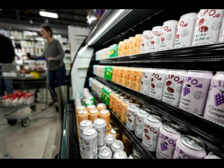 Cans of Olipop, a drink containing botanicals, plant fibres, and prebiotics, are displayed at a Kroger supermarket, Friday, April 12, 2024, in Marietta, Georgia. The frenzy of functional beverages – drinks designed to do more than just taste good or hydr