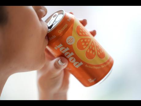 A person drinks Poppi, a prebiotic soda, on Wednesday, April 10, 2024, in New York. A fitness instructor described functional drinks like Poppi as a “guilt free indulgence”.