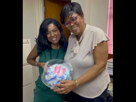 St Thomas Eastern Member of Parliament Dr Michelle Charles gifts Valrie Curtis a cake wishing her a happy retirement.