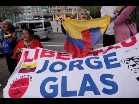 Supporters of former Vice-President Jorge Glas cheer after an Ecuadorian court of justice declared that his arrest inside Mexico’s embassy was illegal, in Quito, Ecuador, on Friday, April 12. However the court ordered that Glas remain in prison to serve 