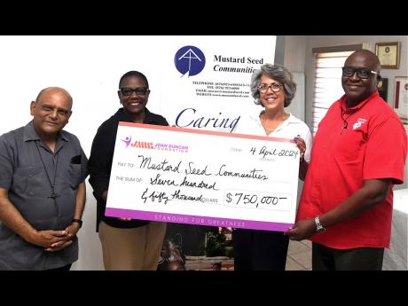 Kim Mair (second right), CEO of the JMMB Joan Duncan Foundation, is the picture of a cheerful giver as she shares in a photo op with (from left) Monsignor Gregory Ramkisoon, founder of Mustard Seed Communities (MSC) in Jamaica, Darcy Tulloch-Reid, executiv