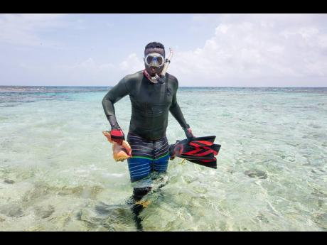 Conservationist Jayden Lawe returns from a dive at Pedro Bank, Jamaica, with queen conch.