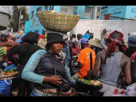 A street vendor balances a basket of vegetables on her head in the Petion-Ville neighbourhood of Port-au-Prince, Haiti, on Wednesday, April 10.