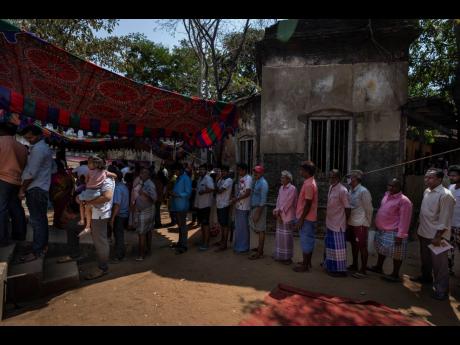 People wait to cast their votes during the first round of polling of India’s national election in Chennai, southern Tamil Nadu state, Friday, April 19.