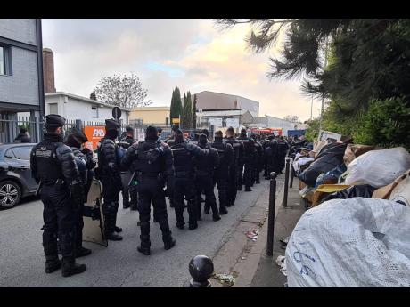 This photo, provided by the Collectif Acces au Droit, shows riot police officers outside a squat Wednesday, April 17, 2024 in Vitry-sur-Seine, outside Paris. With the Paris Olympic Games 100 days away, police carried out a large-scale eviction at France’
