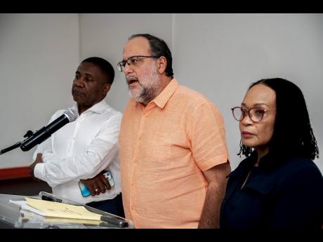 Opposition Leader Mark Golding (centre) speaking at the People’s National Party (PNP) press conference at the PNP headquarters in St Andrew yesterday. The PNP called a press conference to speak on the Constitutional Court ruling in relation to Director o