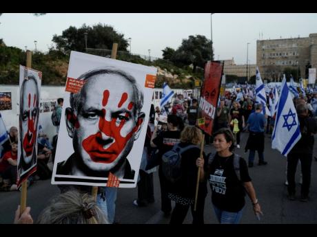 People take part in a protest against Israeli Prime Minister Benjamin Netanyahu’s government and call for the release of hostages held in the Gaza Strip by the Hamas militant group outside of the Knesset, Israel’s parliament, in Jerusalem, Sunday, Marc