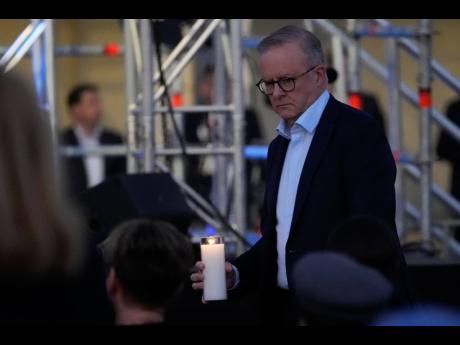 On Sunday, Australian Prime Minister Anthony Albanese carries a candle during a candlelight vigil at Sydney’s Bondi Beach to remember victims of a knife attack at a nearby shopping mall in Australia. 