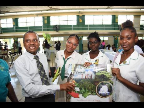 From left: Excelsior High Principal Deanroy Bromfield, student Alexia Dyer, deputy head girl Nathania Lungrin and student Kennesa Farquharson hold a chart and a plant that were presented to school during Monday’s World Earth Day celebration.