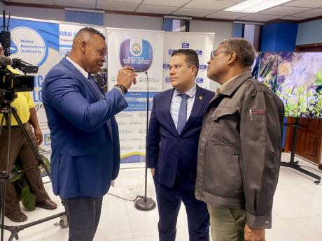 Kevin Kerr (left), acting president of the National Water Commission, speaking with Matthew Samuda, minister without portfolio in the Ministry of Economic Growth and Job Creation, and Peter Clarke, managing director of the Water Resources Authority, after 