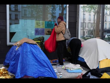 A migrant packs his belongings in a makeshift camp in Paris. 