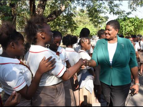 Sian Wilson (right), acting principal of Calabar High School, shakes hands with female students of Mona High School when she and several boys from the Red Hills Road-based institution visited the school to participate in the devotion on Tuesday.