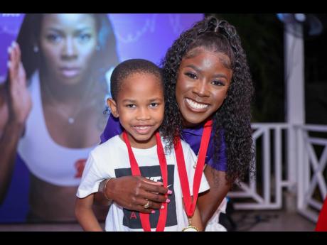 Scotiabank brand ambassador, Shericka Jackson, the Jamaican sprinting sensation, proudly wears her Scotiabank medal alongside young fan Luke Stewart.