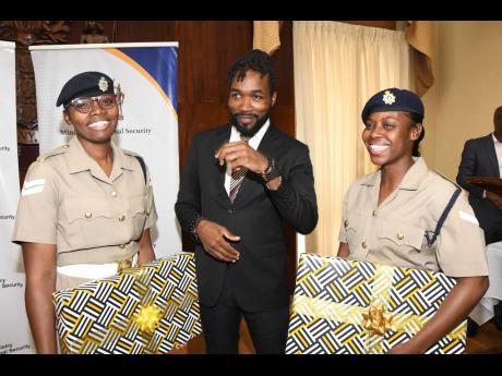 John-I Brown (centre), account executive, MC Systems, jokes with Corporal Omeaka Oates (left), and Lance Corporal Jamelia Myers of the Jamaica Defence Force during the awards ceremony for the National Cybersecurity Competition SheSecures Jamaica at Jamaica