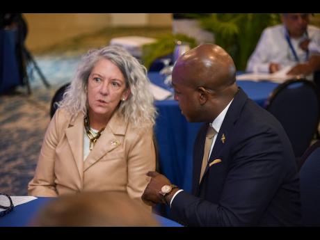 Pamela Foster, the USAID Jamaica Acting Country Representative in conversation with Minister of Labour and Social Security, Pearnel Charles Jr at the Positive Pathways Private Sector Forum on Tuesday at The Jamaica Pegasus hotel in New Kingston.