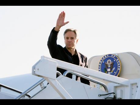 Secretary of State Antony Blinken waves as he boards a plane at Andrews Air Force Base, Maryland, en route to China. 